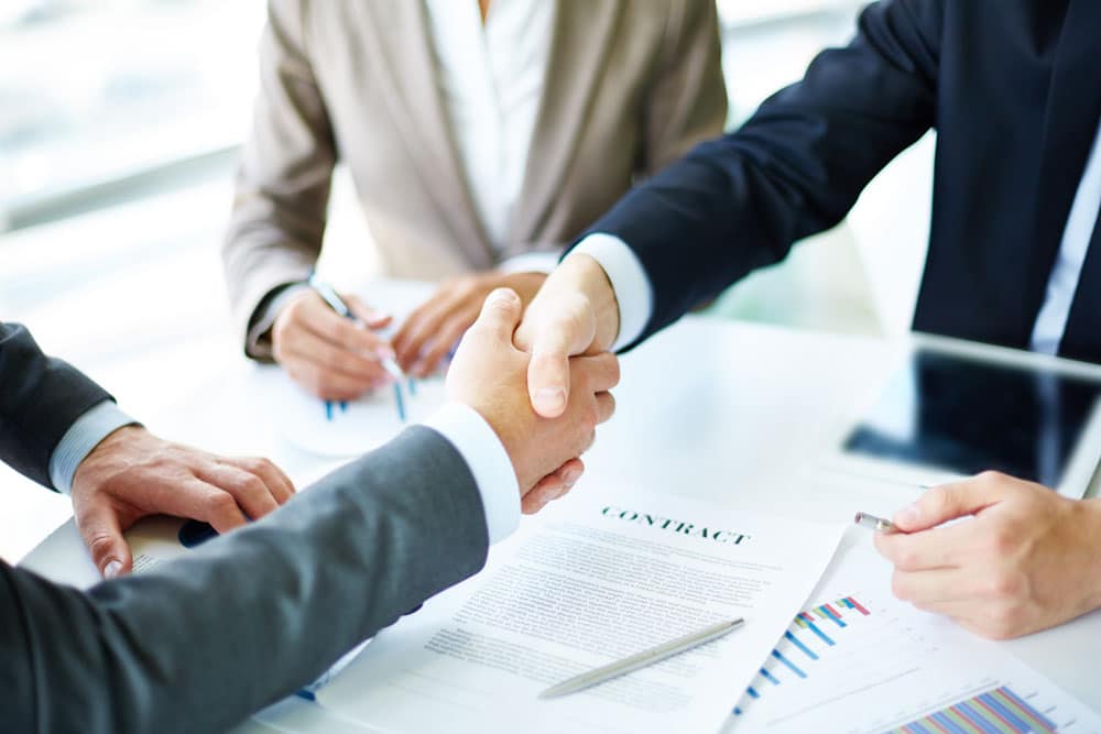 AP Professionals employees exchange a handshake finalizing a business deal